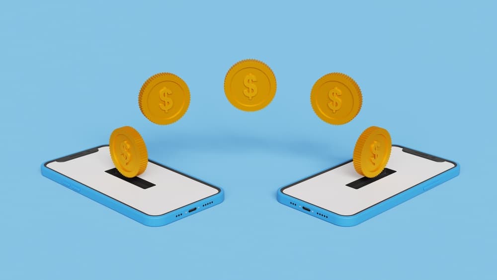 Representação de dois celulares com moedas sendo transferidas de um para o outro, representando transferências digitais. 