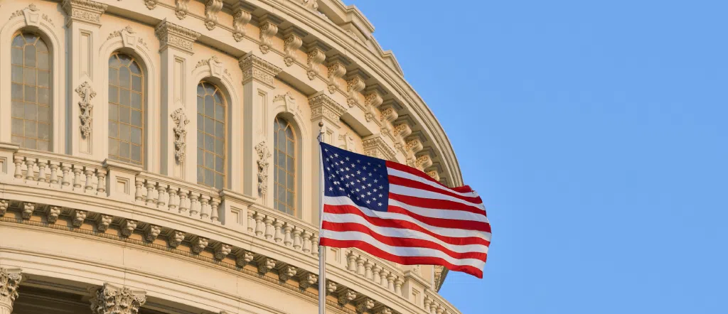 Bandeira dos Estados Unidos em frente a monumento.