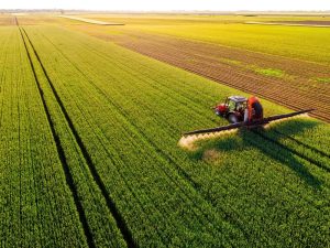 Equipamento trabalhando no campo, simbolizando o agronegócio.