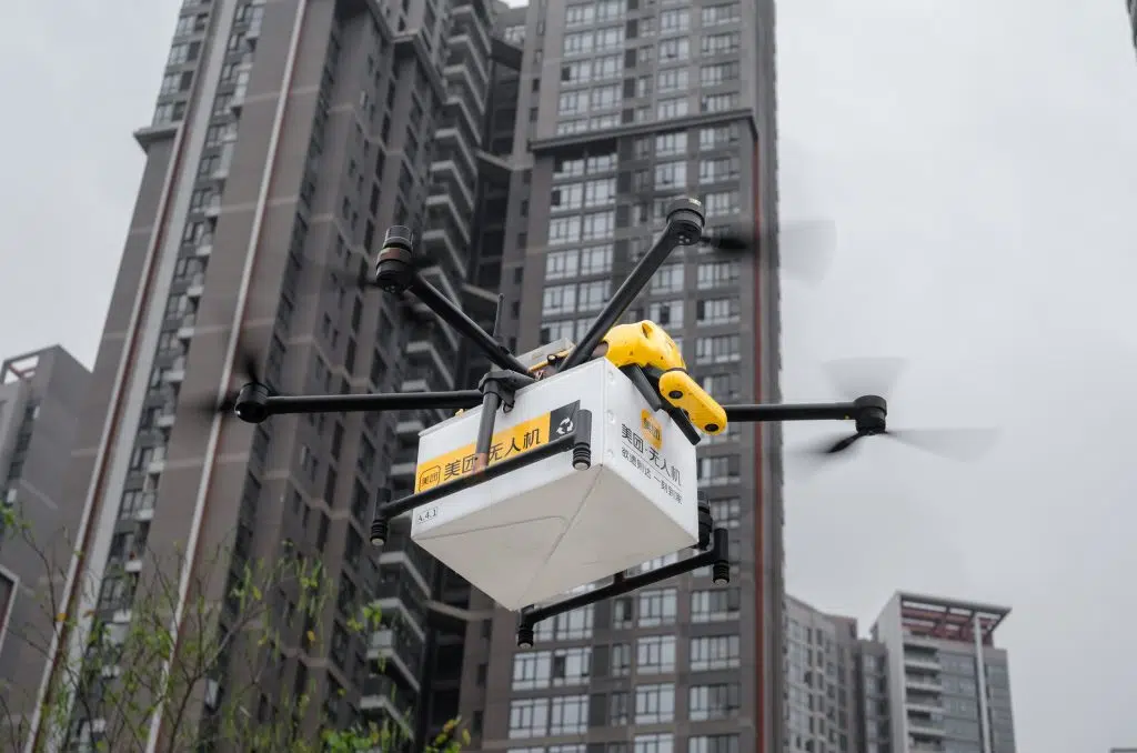 drone da empresa meituan voando com uma caixa para entrega