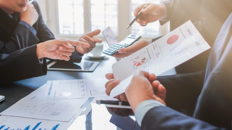 empresários mostrando relatórios do btg empresas