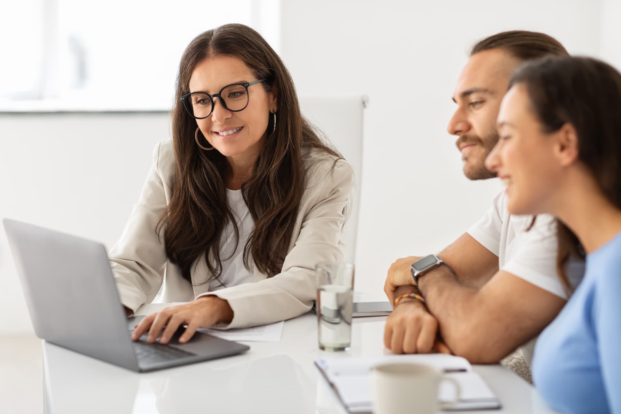 imagem mostra um casal conversando com a sua assessora de investimentos
